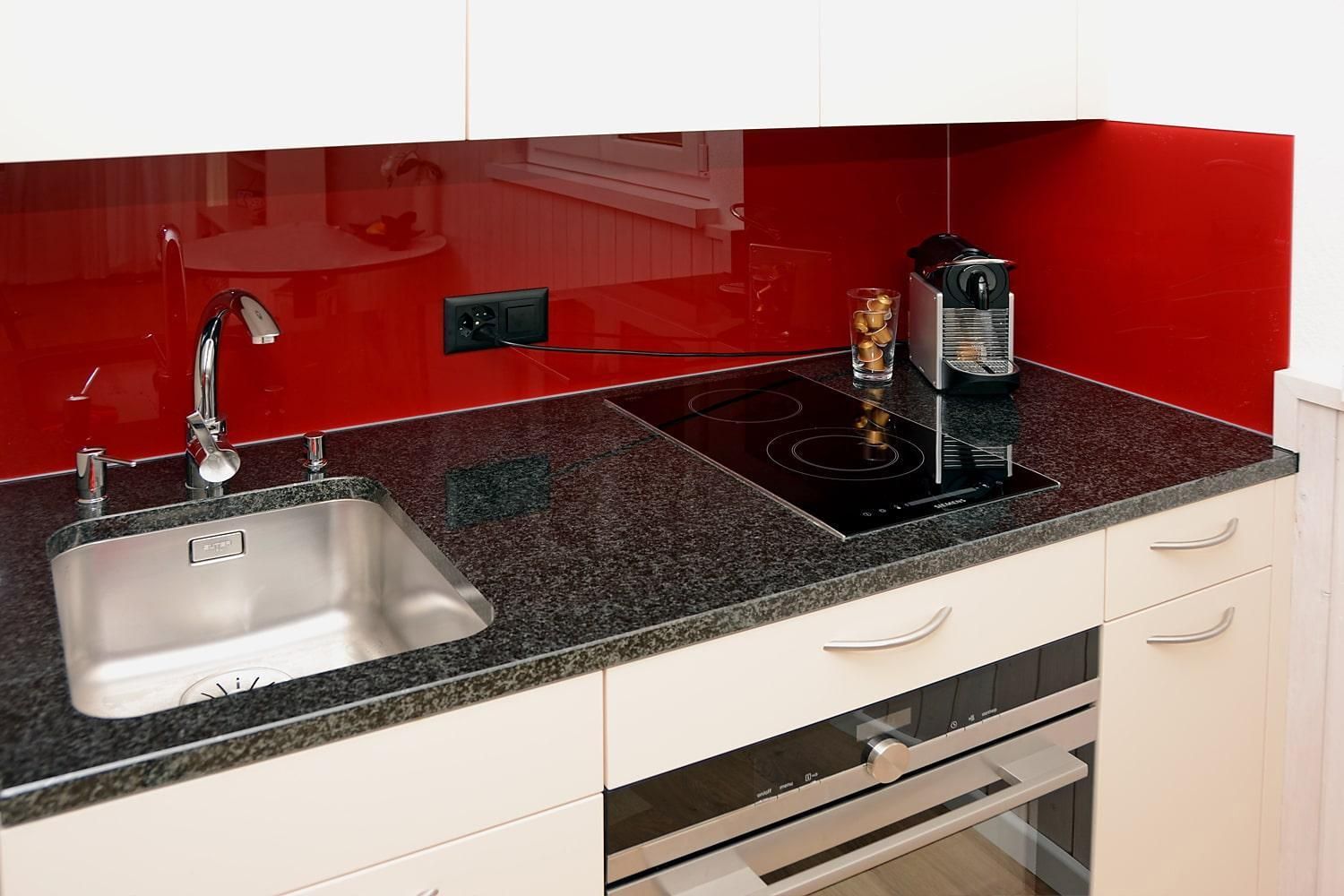 Küche: Spülbecken, Kochherd und Kaffeemaschine - Ferienwohnung Studio 25 - Haus Green - Davos Platz